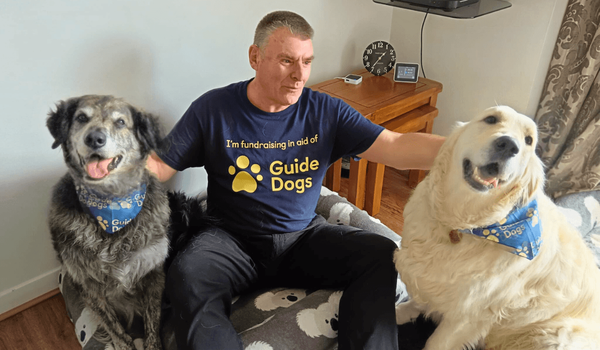 Bobby and Murphy, two gorgeous doggies, sit wearing their Guide Dogs bandanas